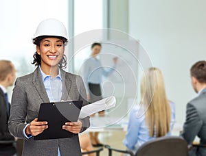 Businesswoman in white helmet with clipboard