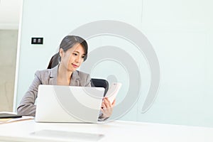 Businesswoman woman using cellphone and laptop computer in conference room