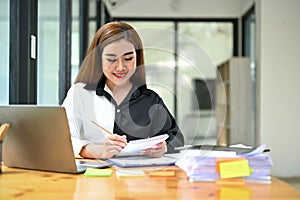 A businesswoman working on business documents and analyzing financial reports