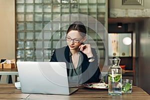 Businesswoman working on a coffee break. Businesswoman working on laptop in a high-end restaurant