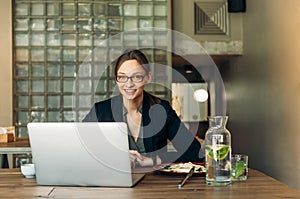 Businesswoman working on a coffee break. Businesswoman working on laptop in a high-end restaurant