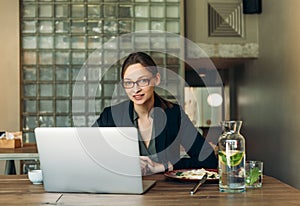 Businesswoman working on a coffee break. Businesswoman working on laptop in a high-end restaurant