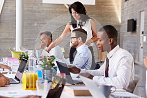 Businesswoman Working With Colleagues At Boardroom Table