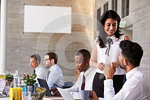 Businesswoman Working With Colleagues At Boardroom Table