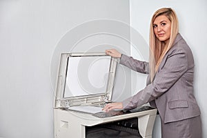 Businesswoman working on a copy machine at the office