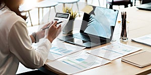 Businesswoman working on desk office with using a calculator to calculate the numbers, finance accounting concept