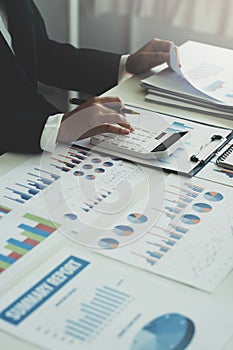 Businesswoman working on desk office with using a calculator to calculate the numbers, finance accounting concept