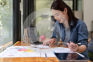 businesswoman working on desk office with using a calculator to calculate the numbers, finance accounting concept