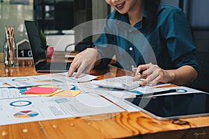 businesswoman working on desk office with using a calculator to calculate the numbers, finance accounting concept