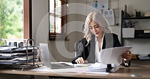 businesswoman working on desk office with using a calculator to calculate the numbers, finance accounting concept.