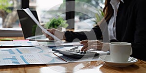 businesswoman working on desk office with using a calculator to calculate the numbers, finance accounting concept