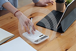 businesswoman working on desk office with using a calculator to calculate the numbers, finance accounting concept