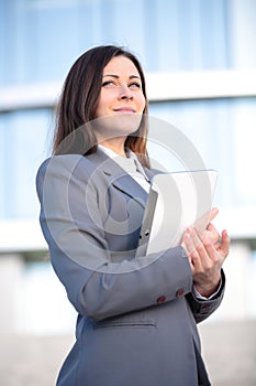 Businesswoman working on digital tablet outdoor over building background