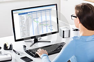 Businesswoman Working On Gantt Chart On Office Desk