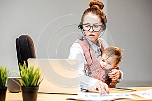 Businesswoman working with her baby son at the office