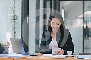 A businesswoman is working at her desk, using a calculator to perform calculations. Finance and accounting concept.