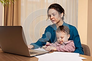 businesswoman working at home with her little child girl