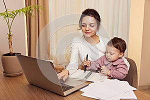 businesswoman working at home with her little child girl