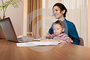 businesswoman working at home with her little child girl