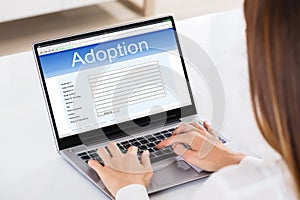 Woman Filling Adoption Paternity Registry In Laptop photo