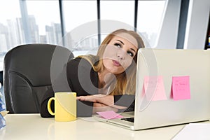 Businesswoman working at laptop computer sitting on the desk absent minded