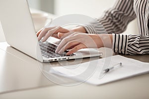 Businesswoman working on laptop, female hands typing on keyboard