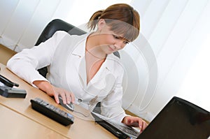 Businesswoman working on laptop in her workstation