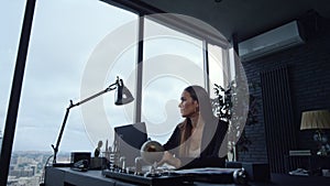 Businesswoman working on laptop in office. Lady typing on laptop keyboard