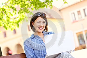 Businesswoman working on laptop in the park