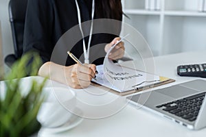 Businesswoman working on laptop with using a calculator to calculate the numbers reading finance accounting concept