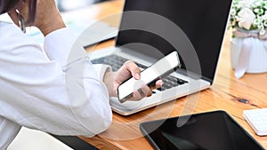 Businesswoman working with laptop and using mobile phone at office.