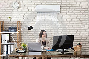 Businesswoman Working In Office With Air Conditioning