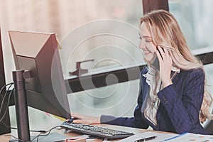 Businesswoman working in office with business phone call while using computer at office desk