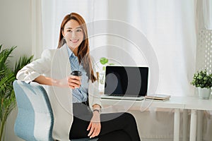 Businesswoman working in the office during coffee break smiling at the window giving a clear vision of work and success instilling