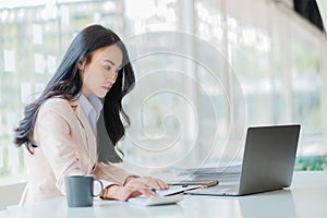 Businesswoman working in the office during coffee break smiling at the window giving a clear vision of work and success instilling