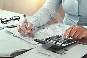 businesswoman working in office on desk using calculator