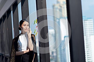 Businesswoman working in the office with looking out of the window