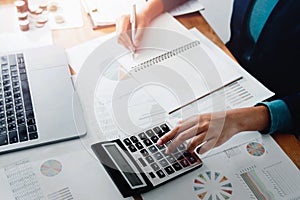 businesswoman working in office with using a calculator to calculate the numbers finance accounting concept