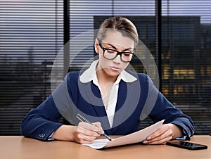 Businesswoman working in office, writing