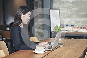 Businesswoman working online at the home office by laptop. Asian young entrepreneurs watching webinars and talking during meeting