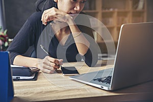 Businesswoman working online at the home office via laptop. Asian young entrepreneurs watching webinars and talking during meeting