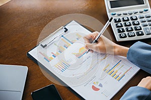 businesswoman working with paperwork charts and graphs and calculator