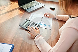 Businesswoman working at the table using a calculator to calculate numbers. Financial accounting concept