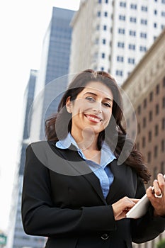 Businesswoman Working On Tablet Computer Outside Office