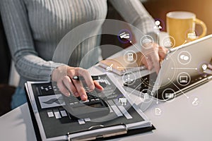 Businesswoman working with tablet and using a calculator to calculate the numbers of static in office.