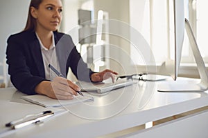 Businesswoman works at the computer at the table in the workplace in the office