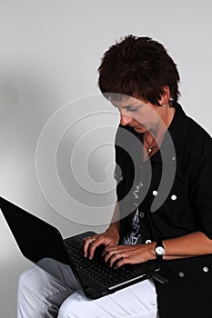 Businesswoman works with laptop on her knees