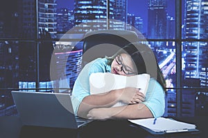 Businesswoman works overtime and sleeping on desk