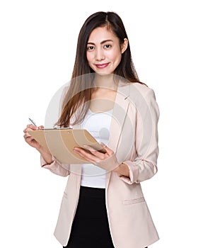 Businesswoman write on clipboard