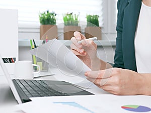 Businesswoman writes on a document at the office desk. Businesswoman or entrepreneur in the home office. Online business,